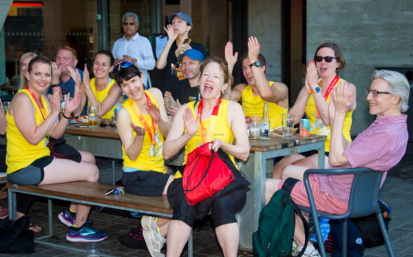 The Team UC post-run celebration in 2018, sitting around a table and cheering.