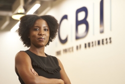 Katie Dash crossing her arms in in the foreground of the CBI logo